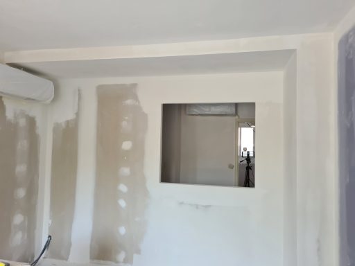 Mur en cours de rénovation avec une ouverture au centre et espaces non finis autour.